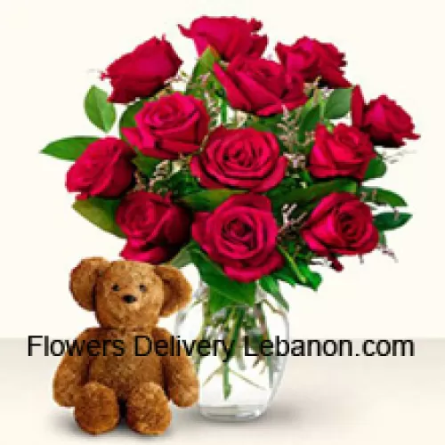 12 Rose Rosse con alcune felci in un vaso di vetro insieme a un adorabile orsacchiotto marrone alto 12 pollici