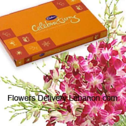 Um belo monte de orquídeas cor-de-rosa junto com uma bela caixa de chocolates Cadbury