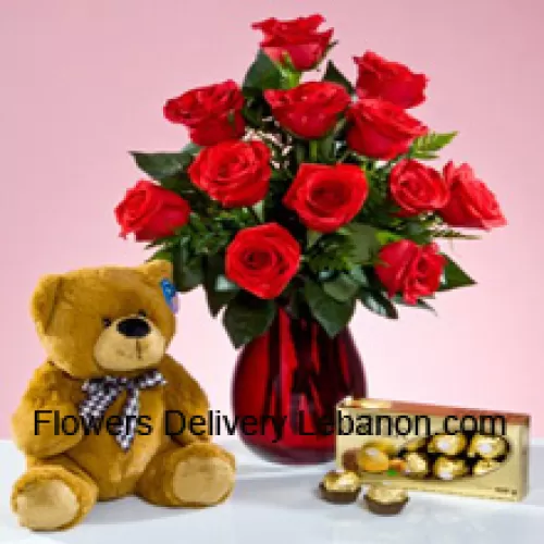 12 Rose Rosse con alcune felci in un vaso di vetro, un carino orsacchiotto marrone alto 12 pollici e una scatola di 16 pezzi di cioccolatini Ferrero Rocher