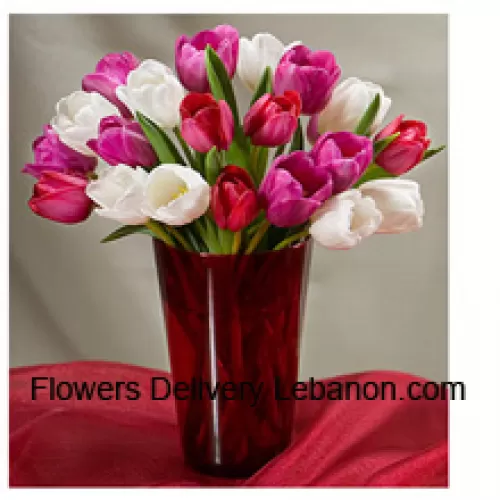 Gemengde gekleurde tulpen met seizoensgebonden opvullers in een glazen vaas - Let op: in geval van niet-beschikbaarheid van bepaalde seizoensbloemen, zullen deze worden vervangen door andere bloemen van dezelfde waarde