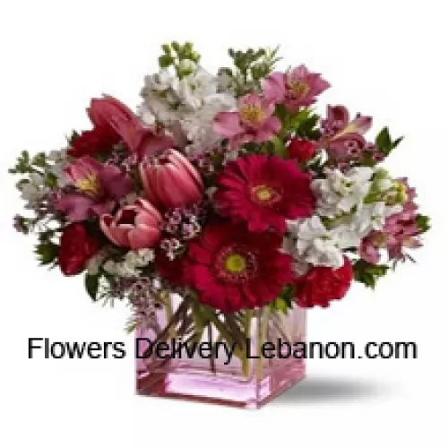 Punaisia ruusuja, punaisia tulppaaneja ja erilaisia kukkia kausittaisilla täytteillä kauniisti järjestettynä lasimaljakossa