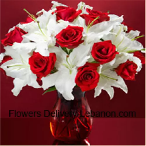 Trandafiri roșii și crini albi cu câteva frunze într-un vas de sticlă