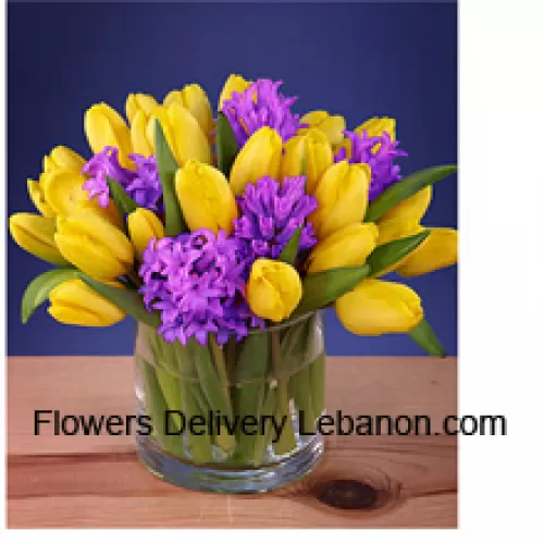 黄色郁金香美丽地摆放在玻璃花瓶中 - 请注意，如果某些季节性花卉不可用，将用价值相同的其他花卉替代