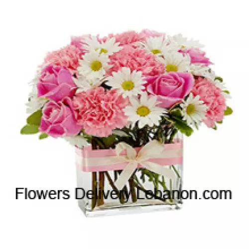 Vaaleanpunaiset ruusut, vaaleanpunaiset neilikat ja erilaisia valkoisia kausikukkia kauniisti järjestettynä lasimaljakkoon