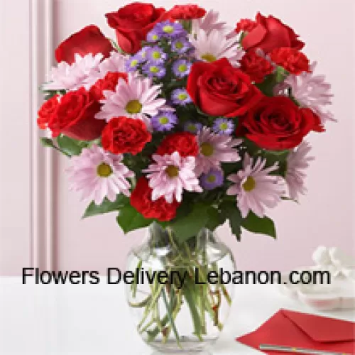 Rose rosse, garofani rossi e gerbere rosa con riempitivi stagionali in un vaso di vetro - 24 steli e riempitivi