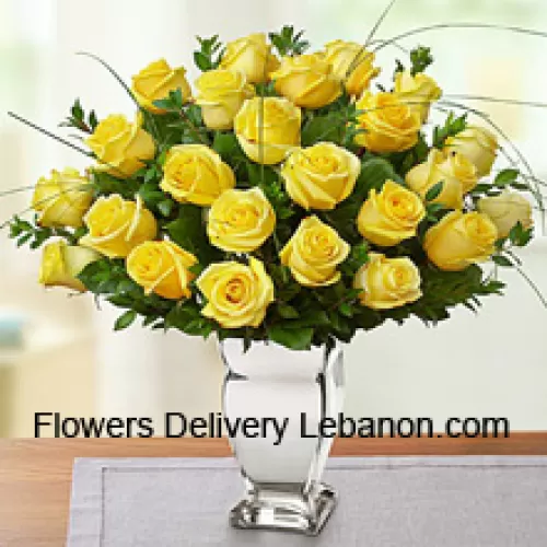 24 Yellow Roses With Some Ferns In A Glass Vase