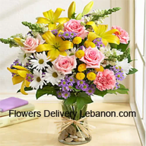 Róże różowe, goździki różowe, białe gerbery i lilie żółte z sezonowymi wypełniaczami w szklanym wazonie