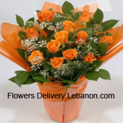 Una hermosa disposición de 18 rosas naranjas con rellenos de temporada