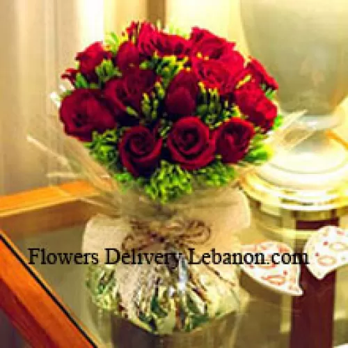 12 crvenih ruža s nekim paprati u vazi