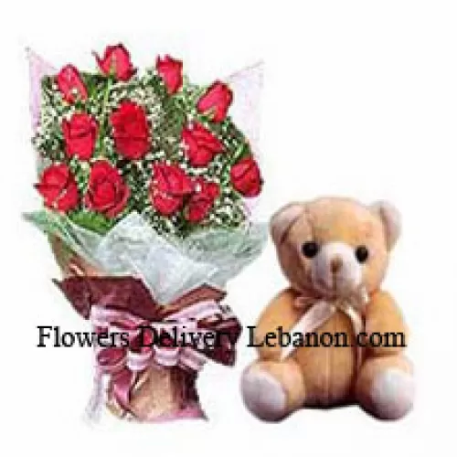 Um buquê de 12 rosas vermelhas com complementos e um pequeno urso de pelúcia fofo
