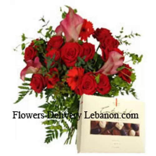 Punaiset gerberat ja punaiset ruusut maljakossa yhdessä suklaarasian kanssa