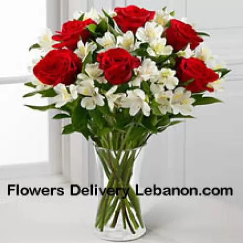שש ורדים אדומים עם פרחים לבנים משתנים ומילאים בצנצנת זכוכית