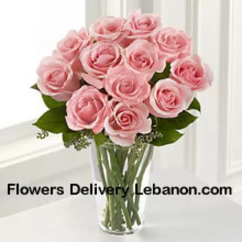 花瓶に入った12本のピンクのバラとシダの束