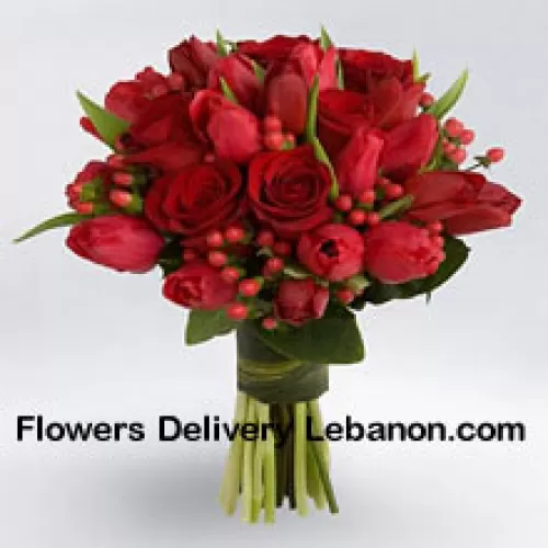 Bukiet czerwonych róż i czerwonych tulipanów z czerwonymi dodatkami sezonowymi.
