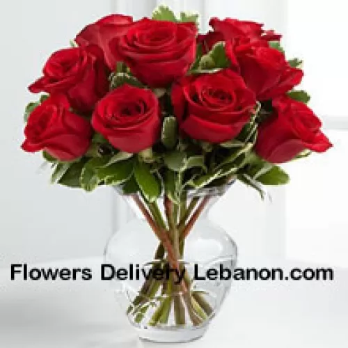 10 Rote Rosen mit einigen Farnen in einer Vase
