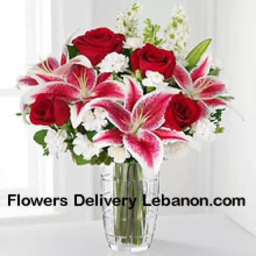 Rosas vermelhas, lírios rosa com flores brancas variadas em um vaso de vidro