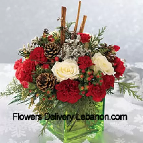 Envíe este ramo de colores festivos - rosas blancas, claveles rojos y verdes navideños - para expresar sus más felices deseos navideños. Arreglado en un cubo de vidrio con palitos de canela y piñas, es un regalo maravilloso para cualquier persona en su lista (Tenga en cuenta que nos reservamos el derecho de sustituir cualquier producto por un producto adecuado de igual valor en caso de no disponibilidad de cierto producto)